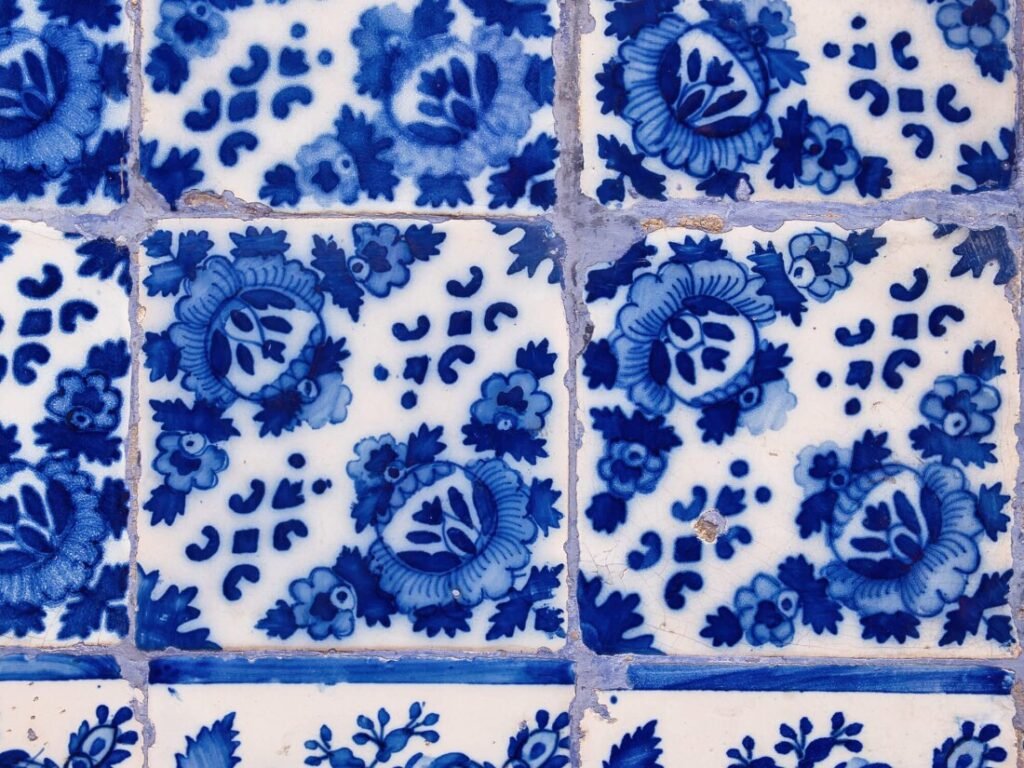 Porto, Portugal: A Slow Travel Guide A macro close-up photograph showcasing the intricate details and hand-painted brushstrokes of traditional blue and white Portuguese azulejo ceramic tiles.