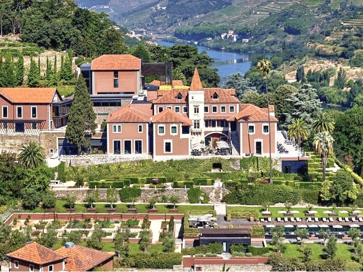 Douro Valley Port Wines: A Portugal Wine Region Guide Aerial view of a magnificently restored 19th century manor with the Douro river behind