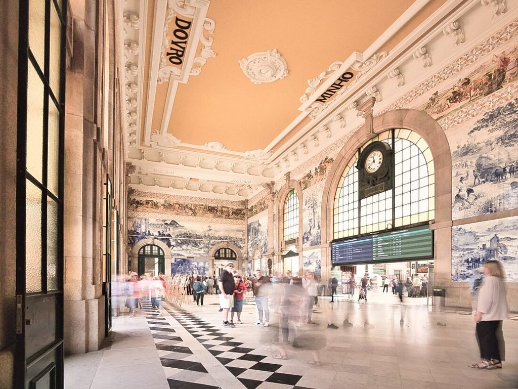 Solo Female Travel in Porto: 3 Day Slow-Travel Itinerary Thousands of historic hand-painted blue and white azulejo tile panels wrap the soaring stone walls inside the grand concourse of Sao Bento railway station in Porto.